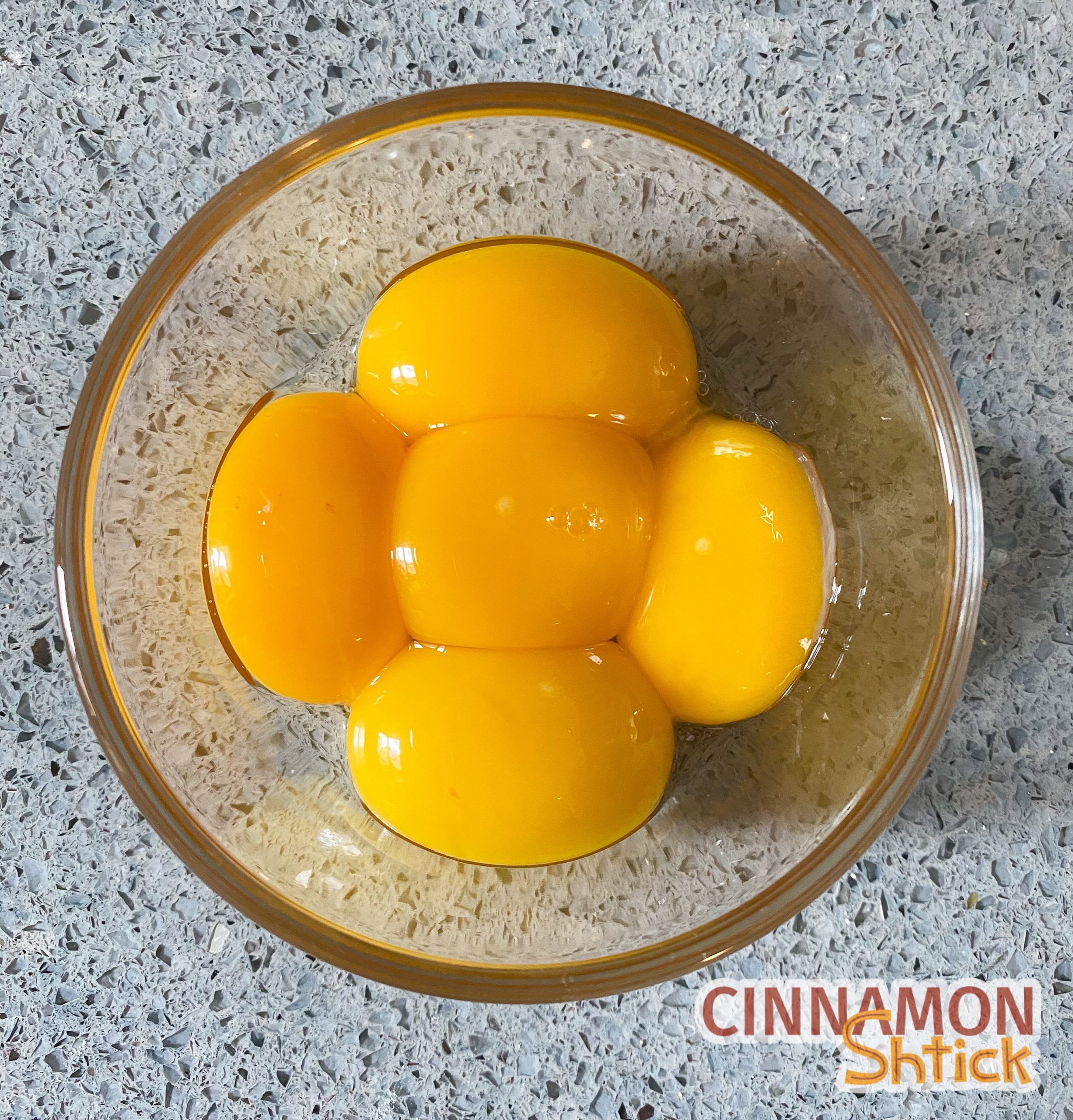 Five egg yolks in a bowl.