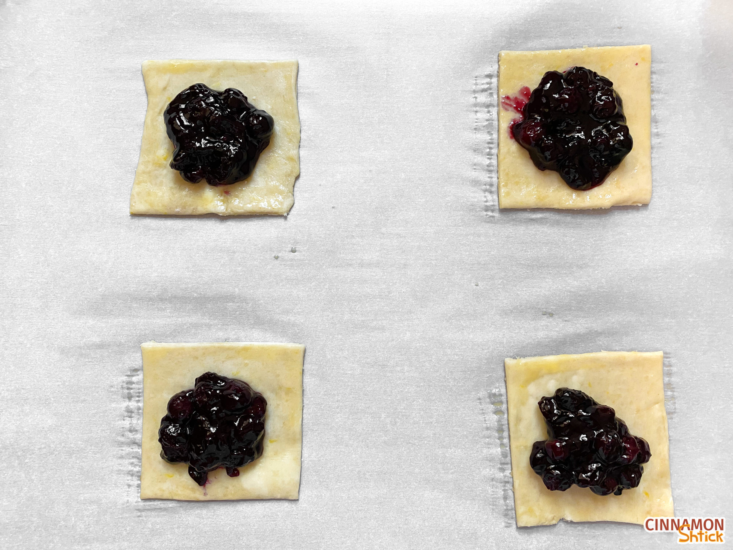 cut dough squares with blueberry filling in middle
