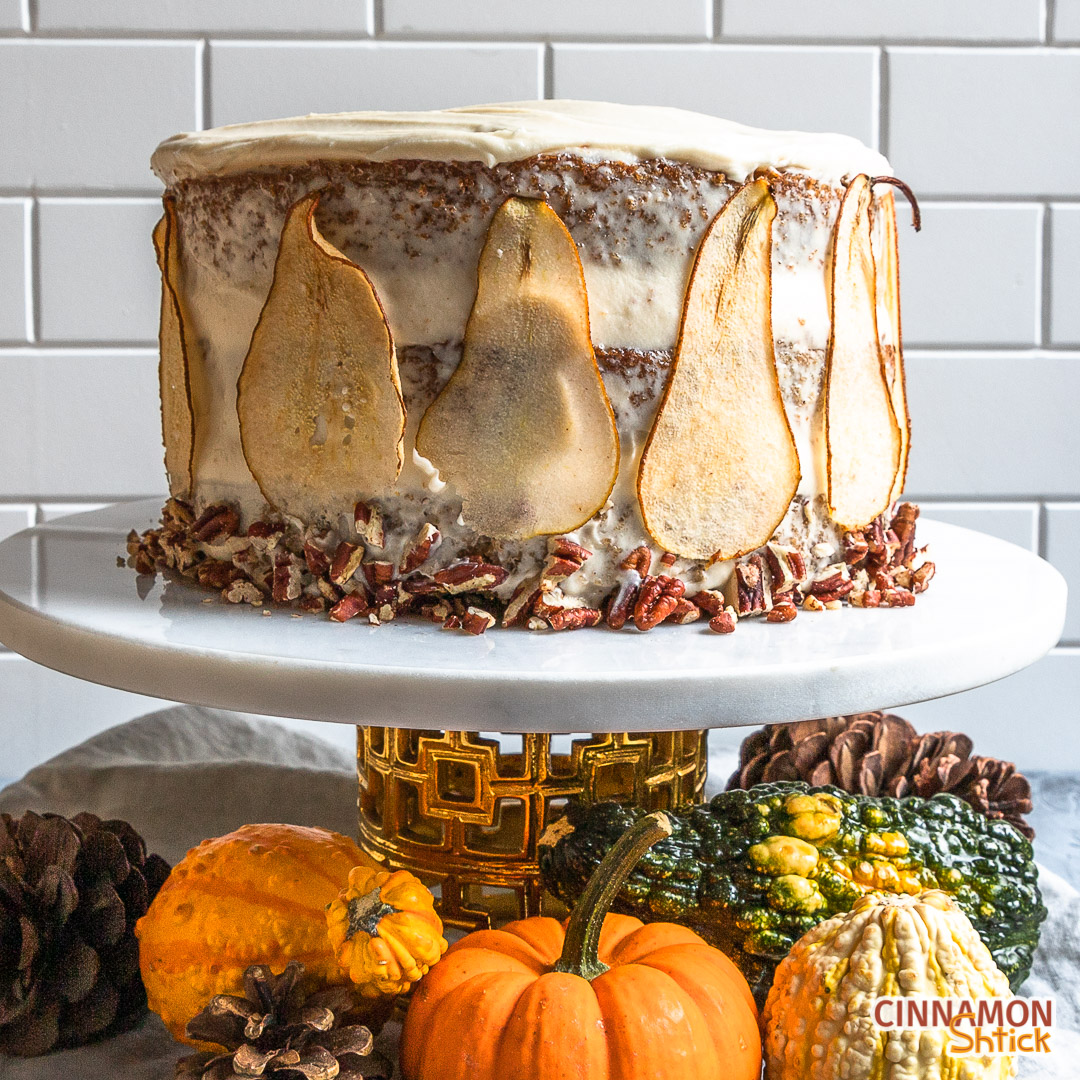Spice cake decorated on cake plate with gourds underneath