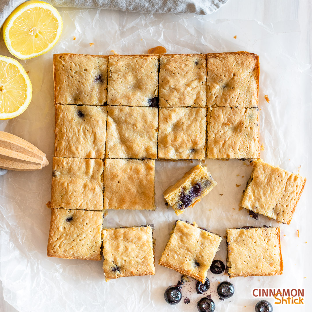 lemon blueberry blondies cut into square with a few misplaced in the front and one on its side