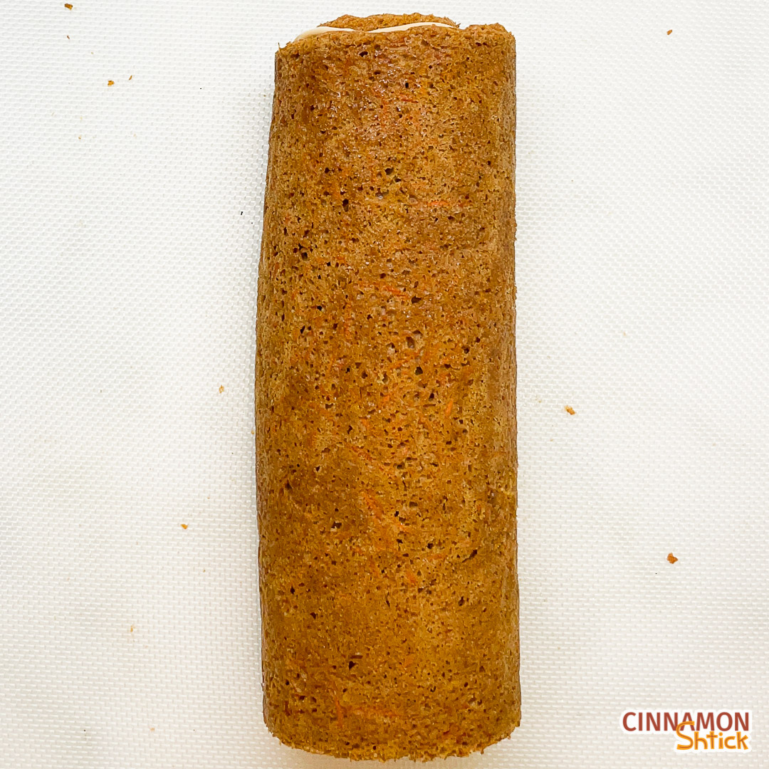 top view of frosted and rolled up graham carrot cake roll