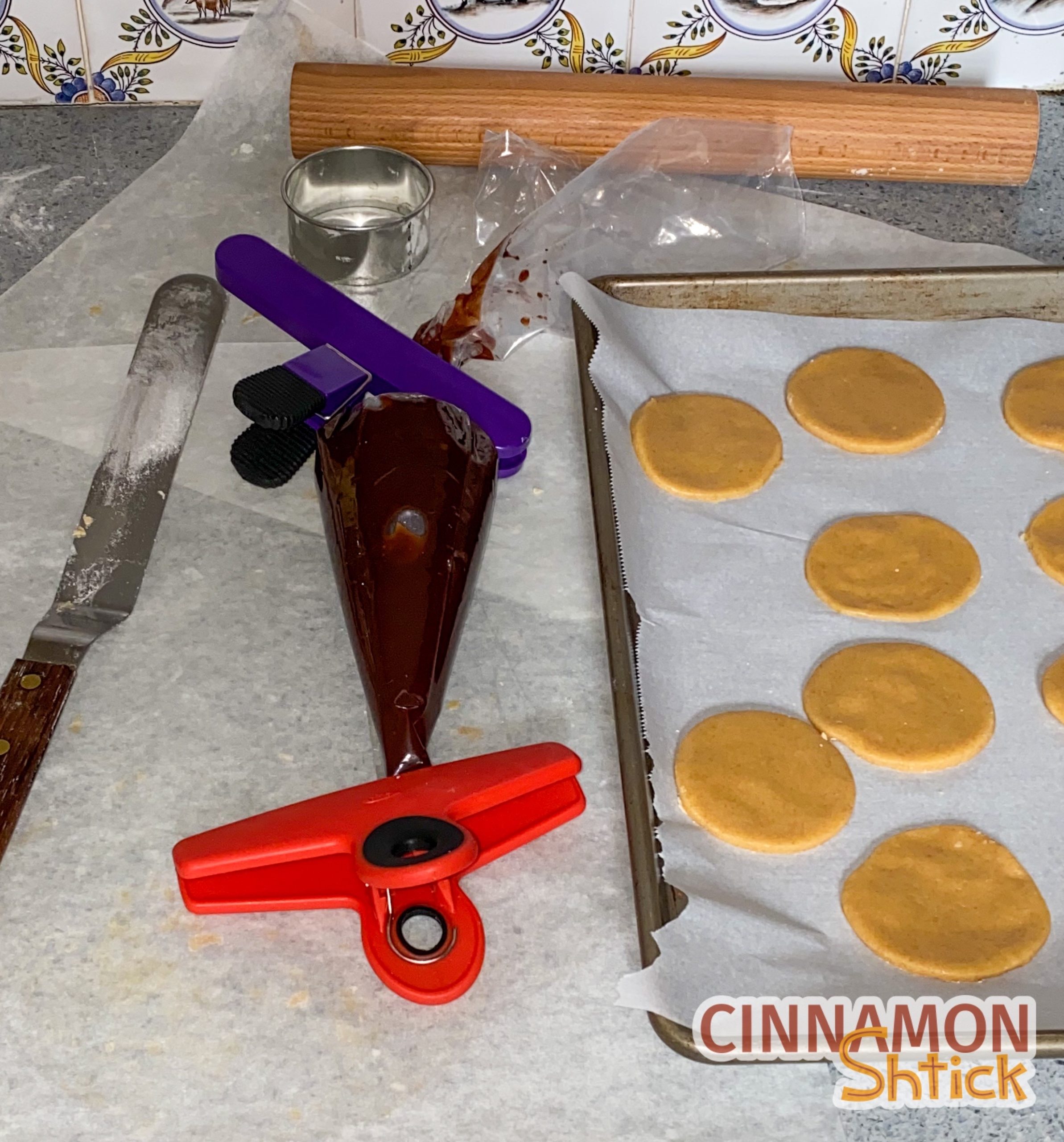 Hamantaschen dough cut in circles with brownie batter in piping bag