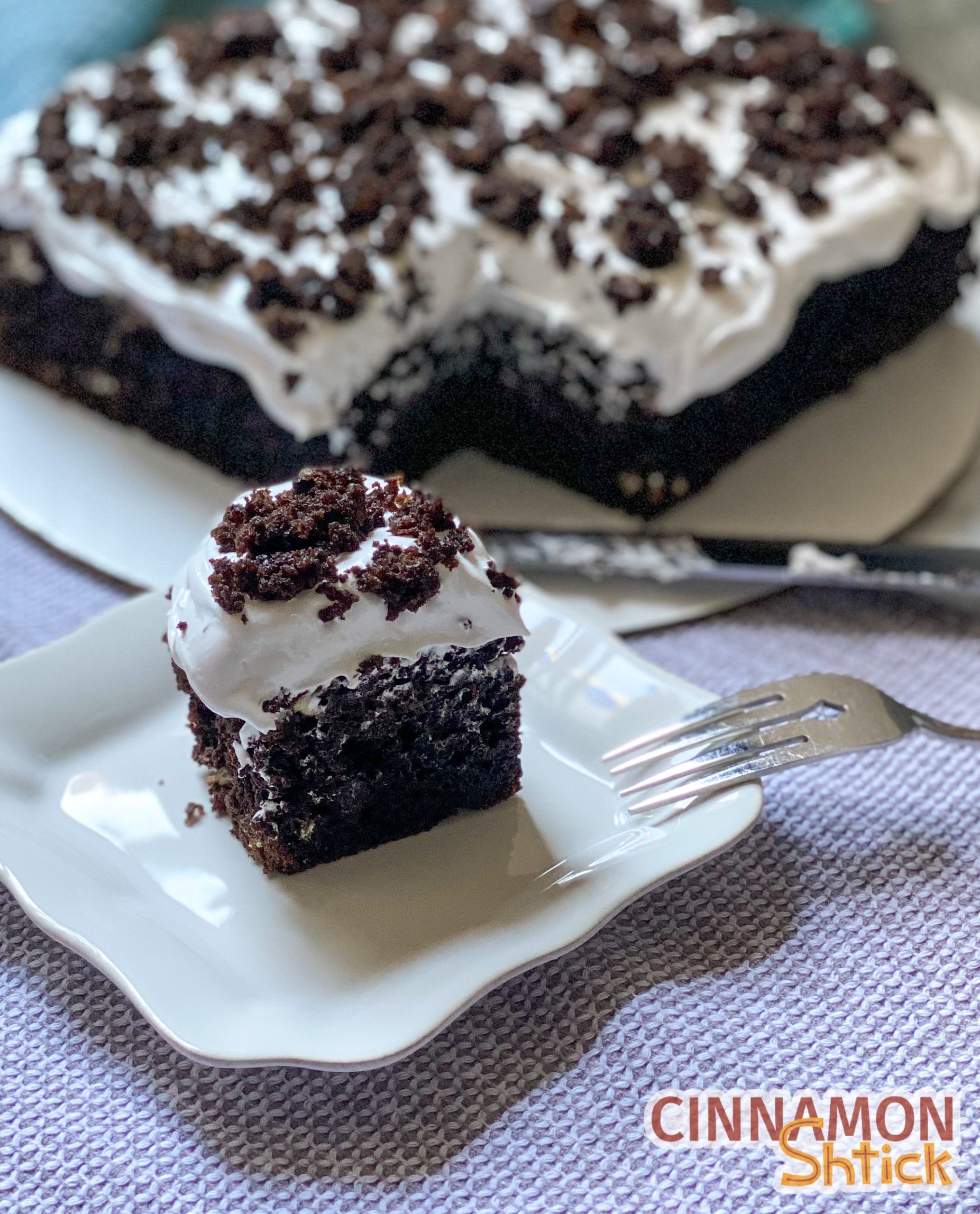 slice of cake on a plate showing the deep chocolate cake with homemade marshmallow cream frosting.