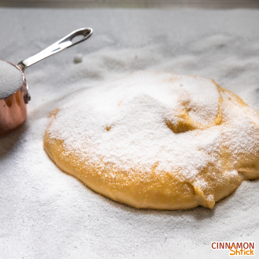 Mound of kichel dough on sugar with sugar on top