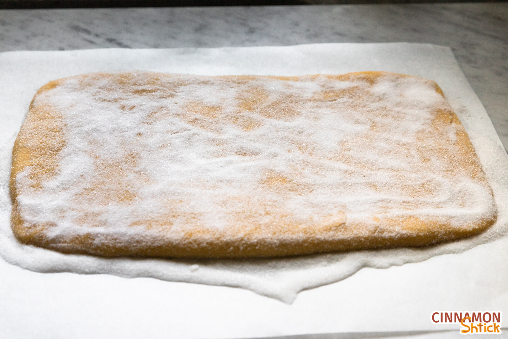 kichel dough spread to 7 inches by 12 inches on a bed of sugar and covered with sugar