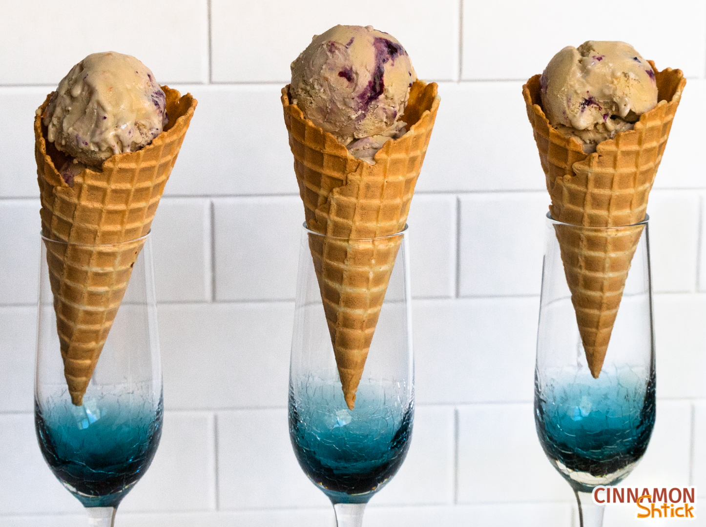 Three cones, standing in champagne glasses, with maple blueberry pie ice cream