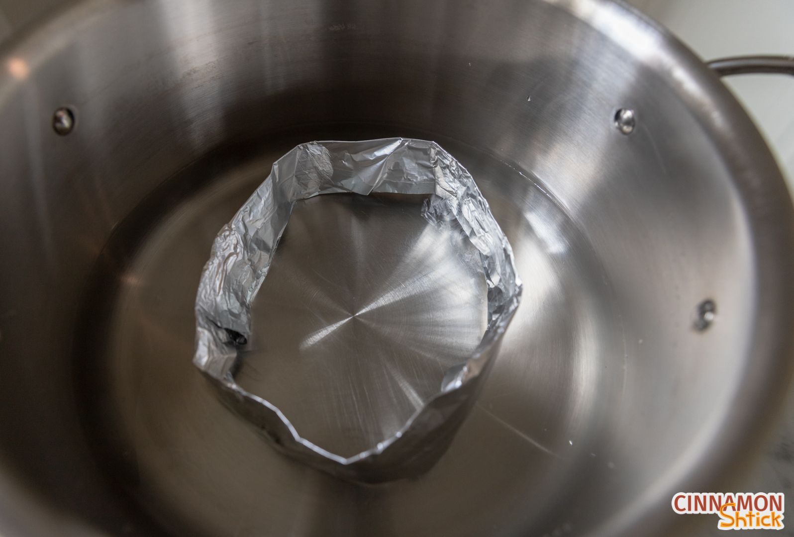 Inside of large pot showing a ring made from heavy duty aluminum foil with water approximately 3/4 of the way up the ring. 