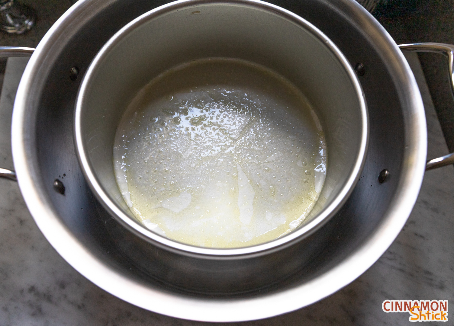 Greased 8 inch round pan resting on the foil circle in the large pot.