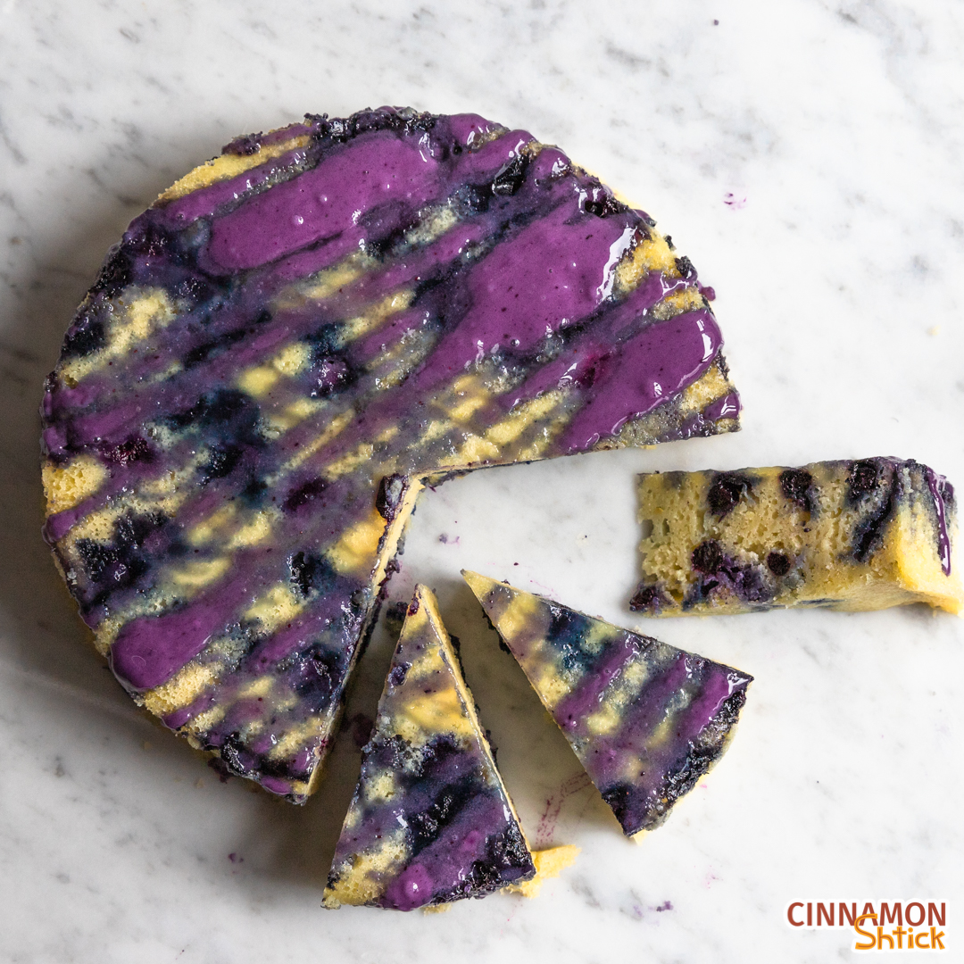 Top view of the finished lemon blueberry stovetop cake with three slices pulled out, one of which is on its side showing the interior of the cake.