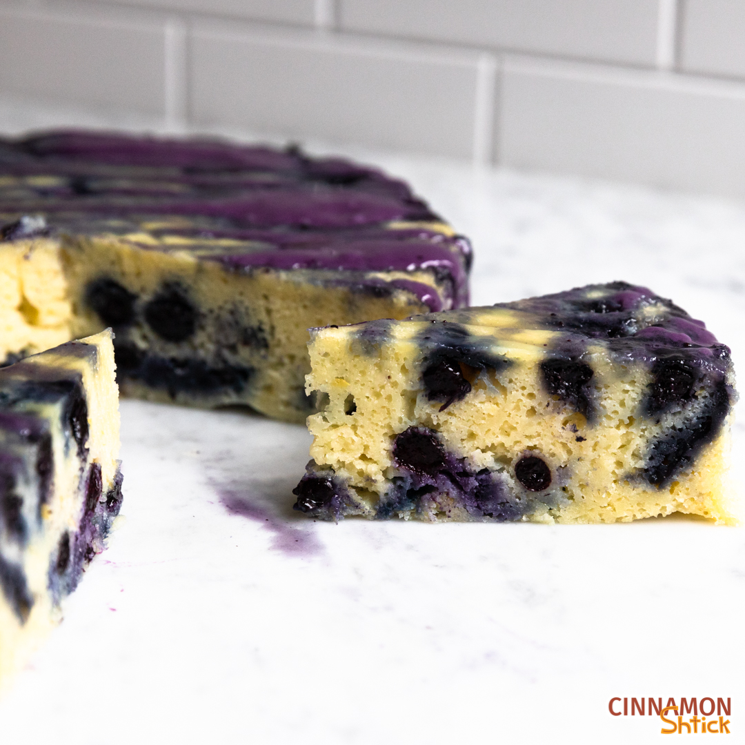 Slice of lemon blueberry stovetop cake separated from rest of cake in background