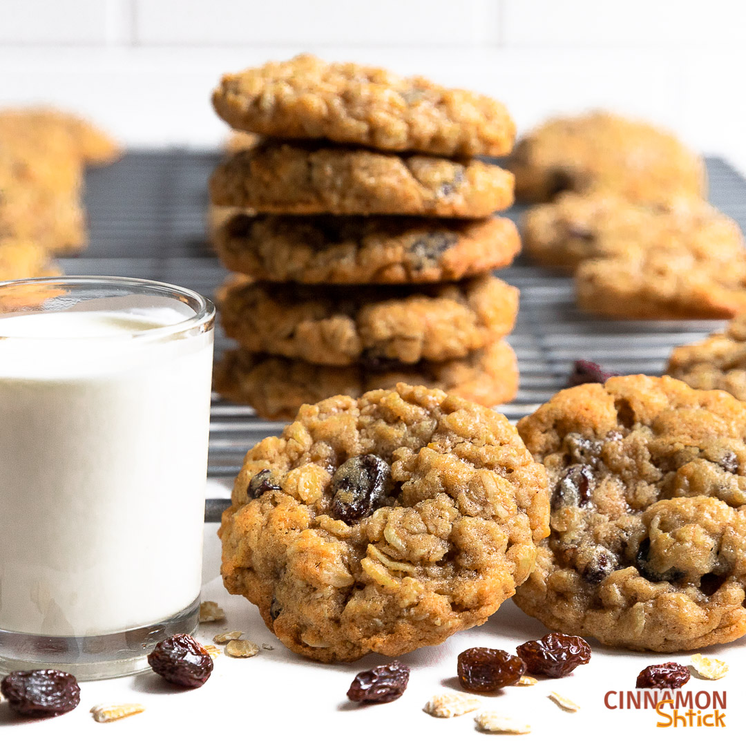 stack of oatmeal raisin cookies with glass of milk