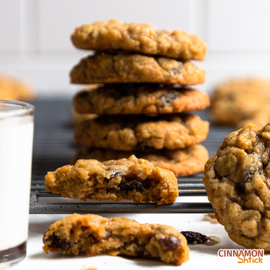 Stack of oatmeal raisin cookies with one broken in half in the front