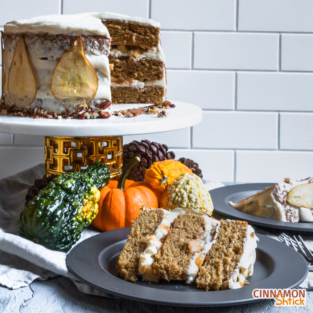 Slice of spice cake on plate in foreground with rest of cake in background