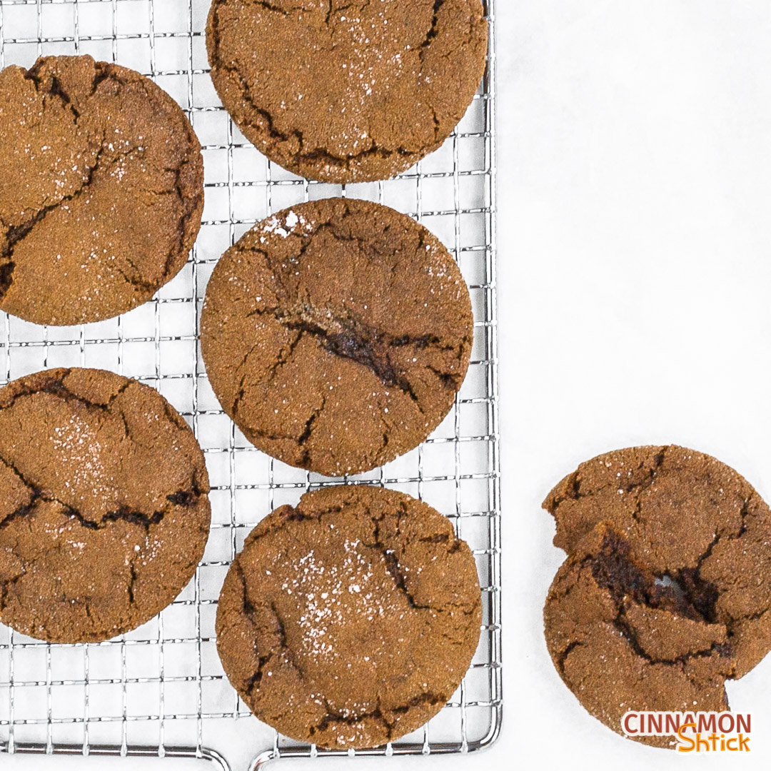 ginger rye molasses cookies on rack with one broken in half