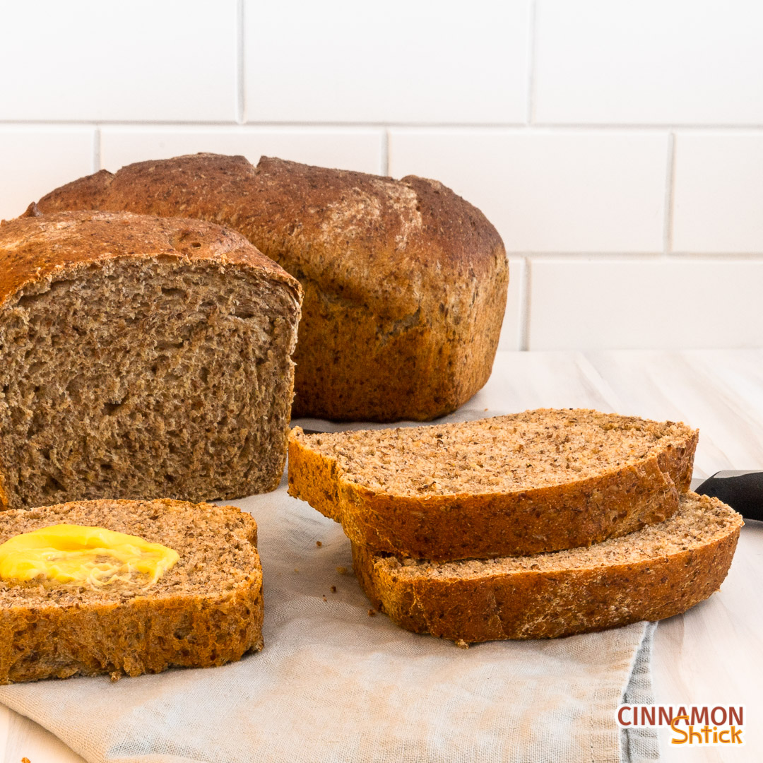 two stacked slices of sourdough discard sandwich bread to the right with a slice with butter melting in the middle to the left