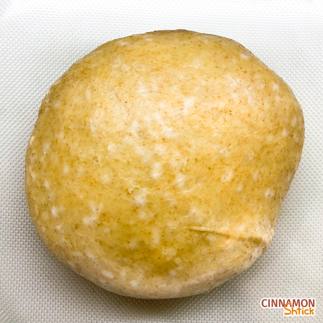 ball of sourdough challah dough after bulk rise showing air pockets on top