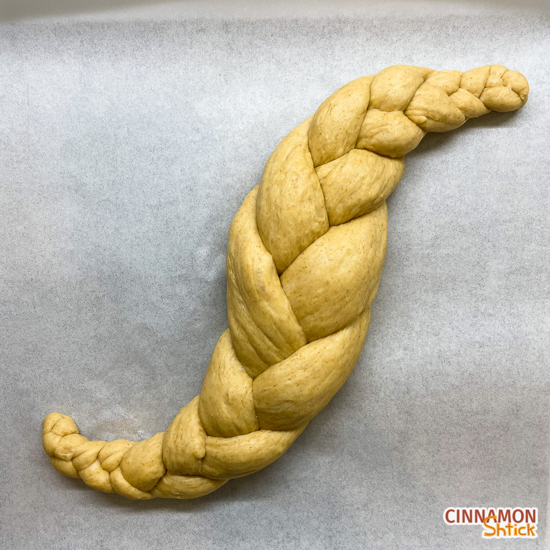 sourdough challah braided with 3 strands in the shape of an S