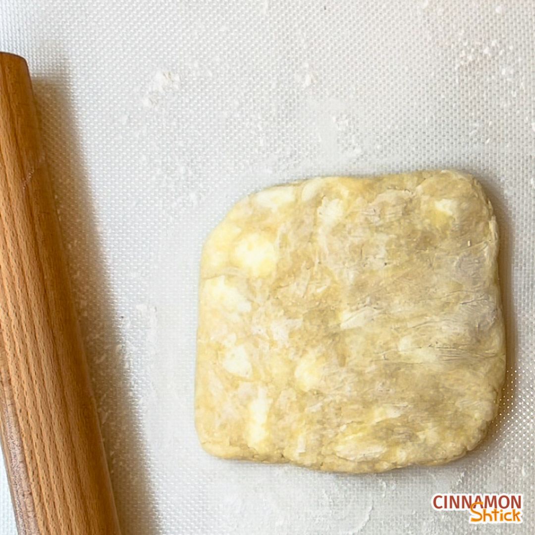 dough with rolling pin on lightly floured surface