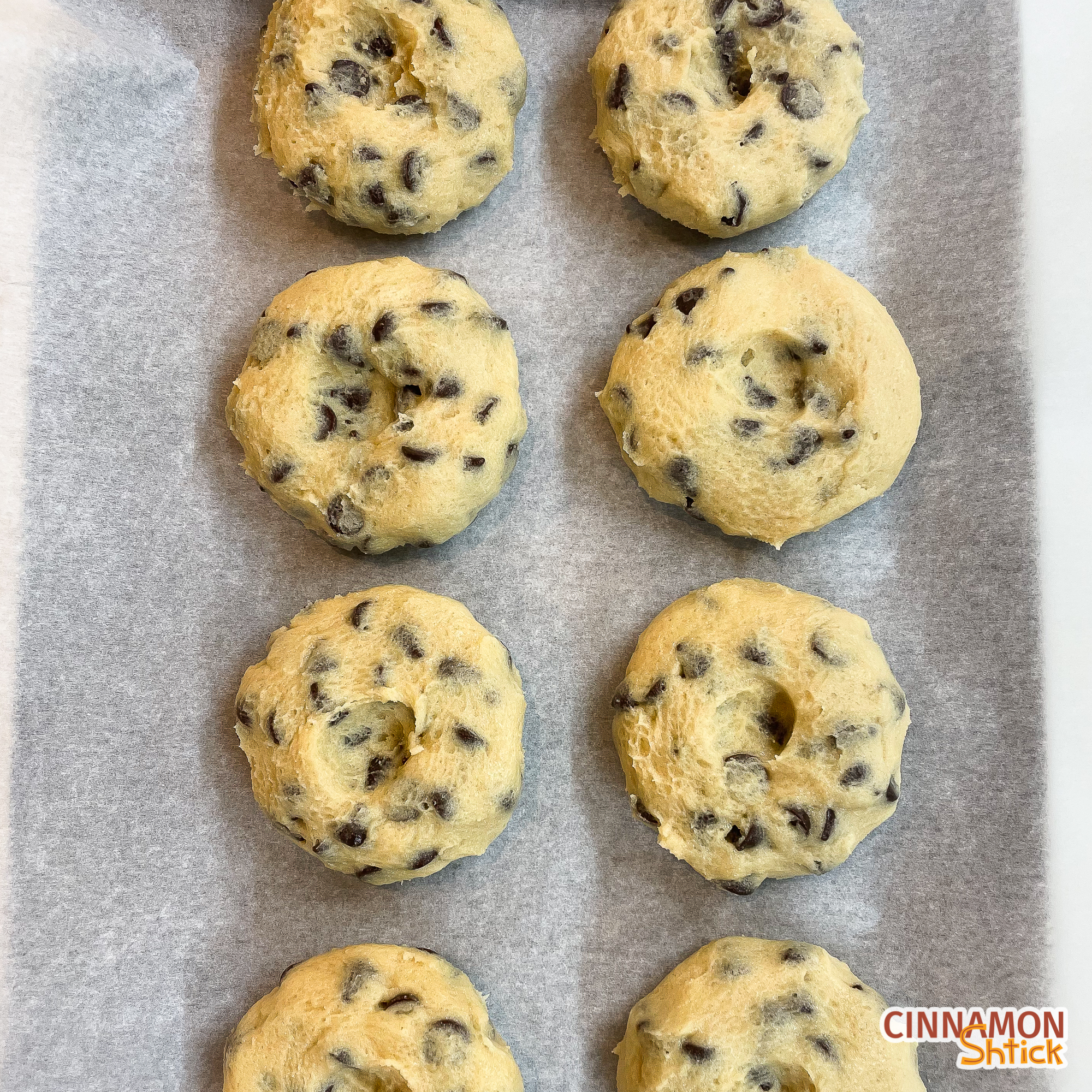 Cookie dough pucks lined up on parchment covered baking sheet