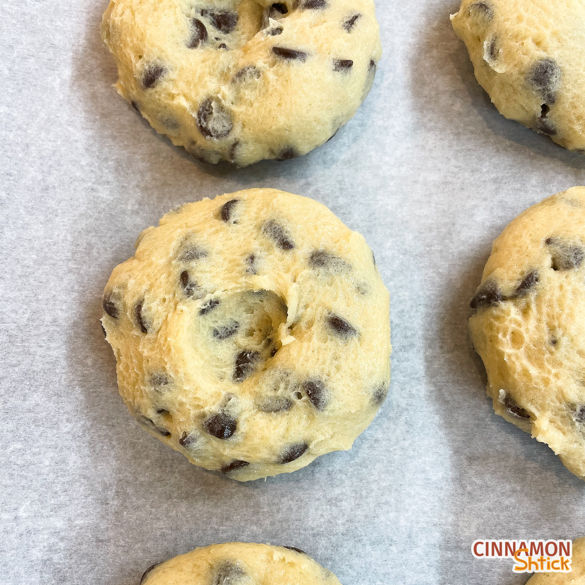 Cookie dough pucks lined up on parchment covered baking sheet