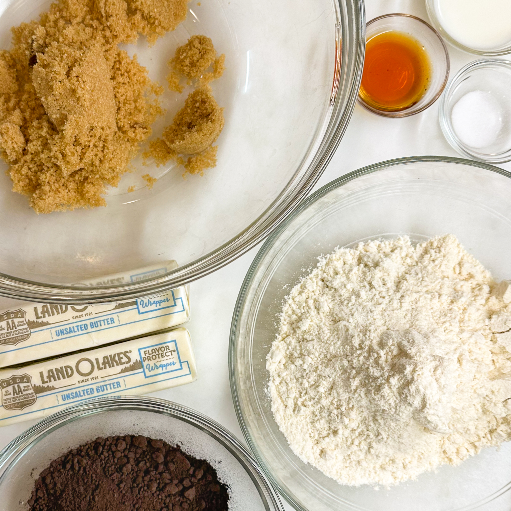 overhead shot of the ingredients for chocolate diamants: brown sugar, butter, milk, vanilla, flour, black cocoa, and salt