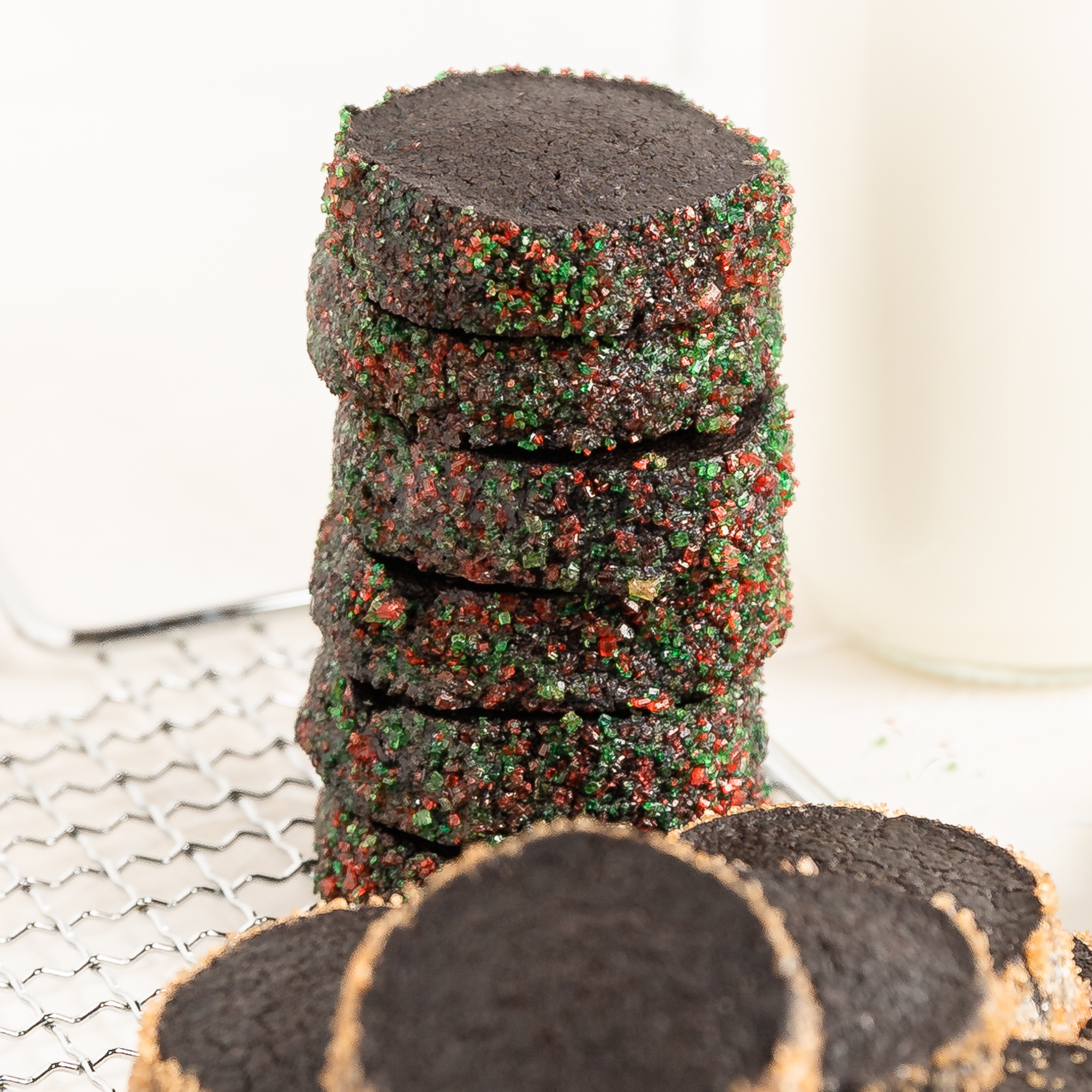 stack of black cocoa diamants coated in red and green colored tubinado sugar