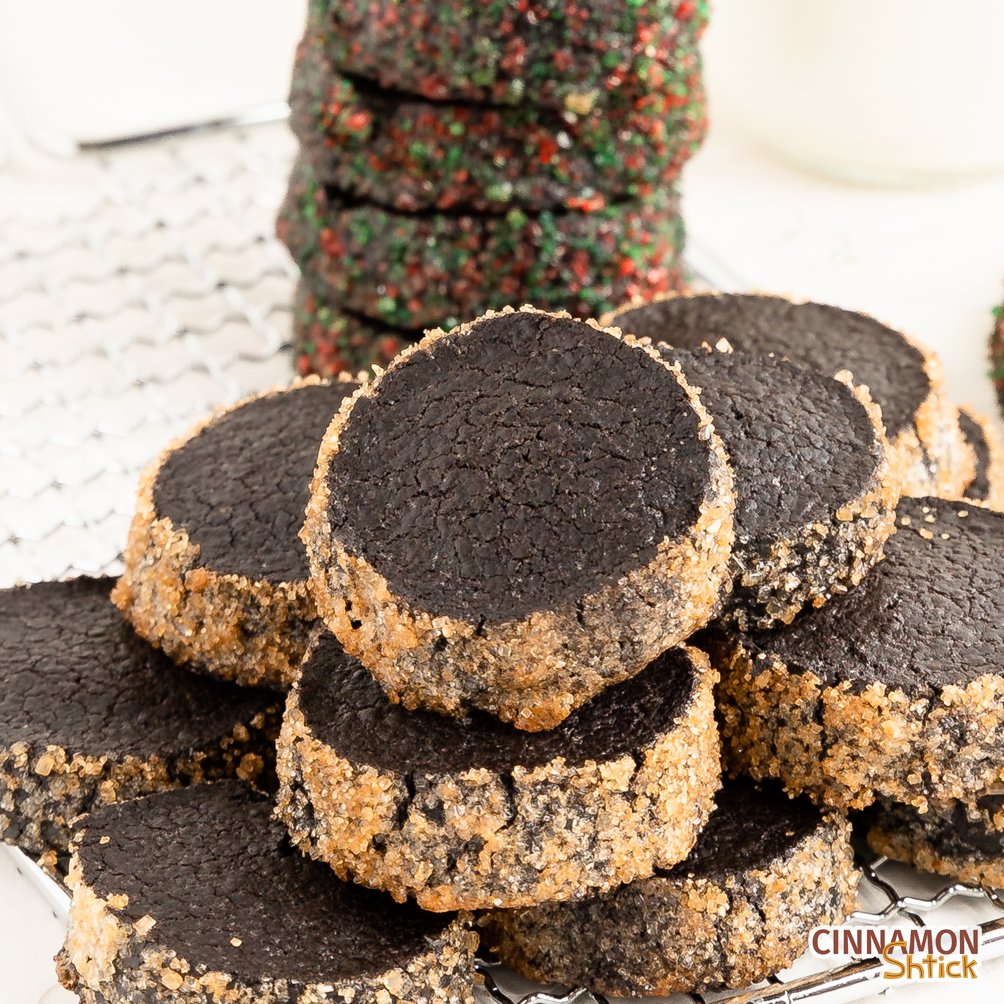 black cocoa diamants piled up on a cooling rack with a stack of more of them in the background