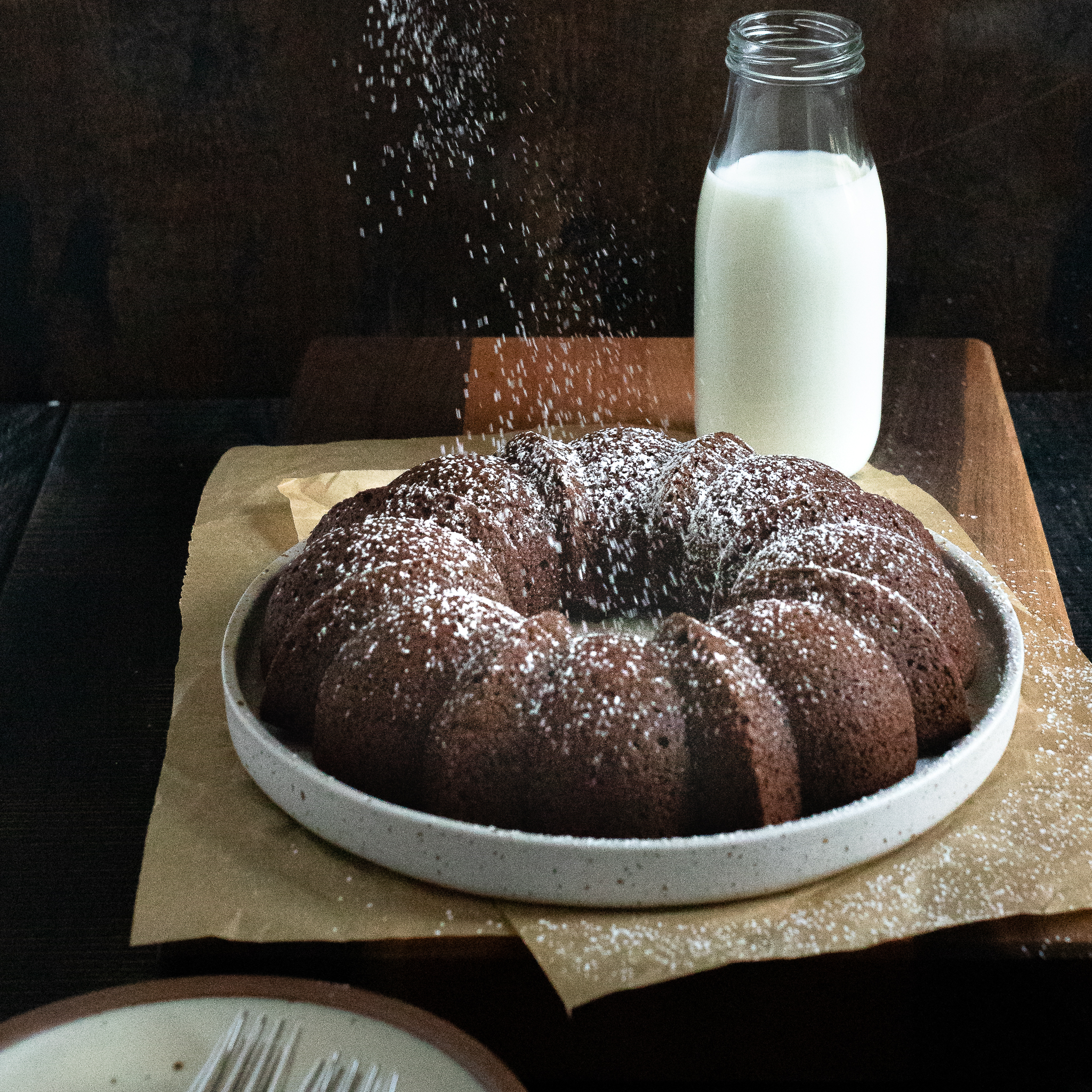 chocolate egg white cake with confectioner's sugar being dusted over it